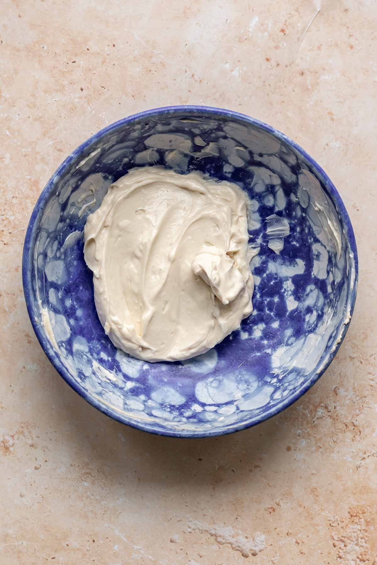 Cream cheese and sugar mixed together in a bowl.