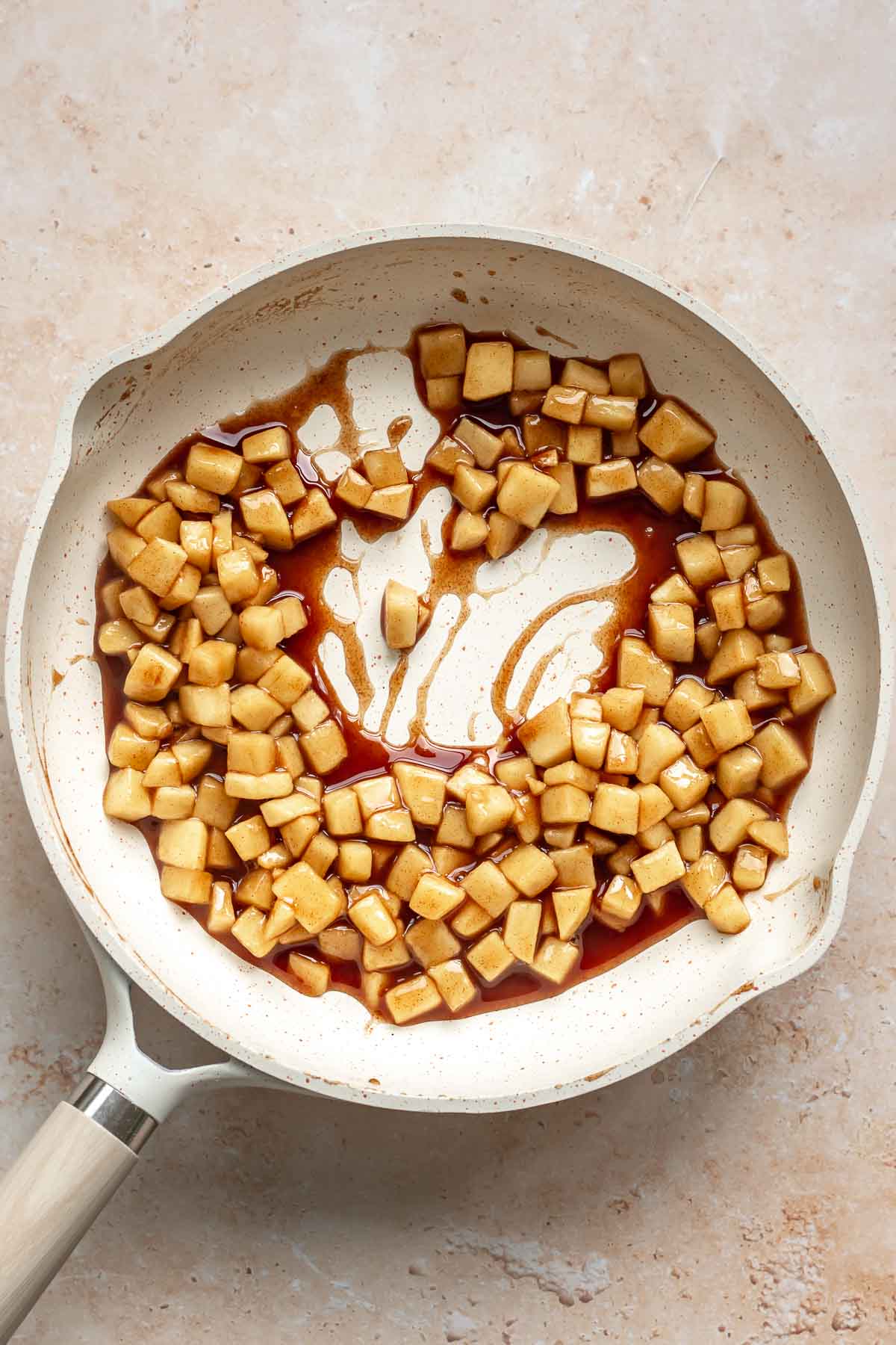 Cooked spiced apples in a frying pan.