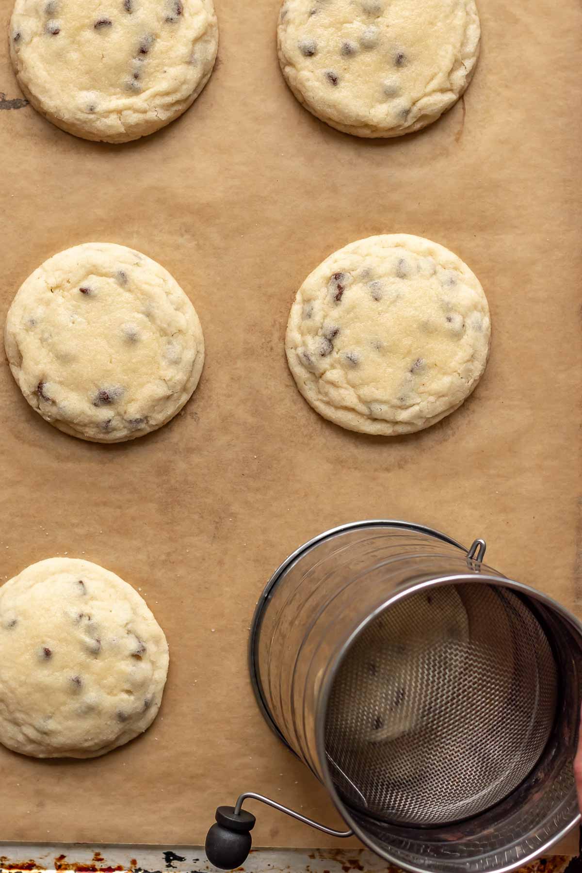 A round object goes around one of the baked cookies to make it perfectly round.