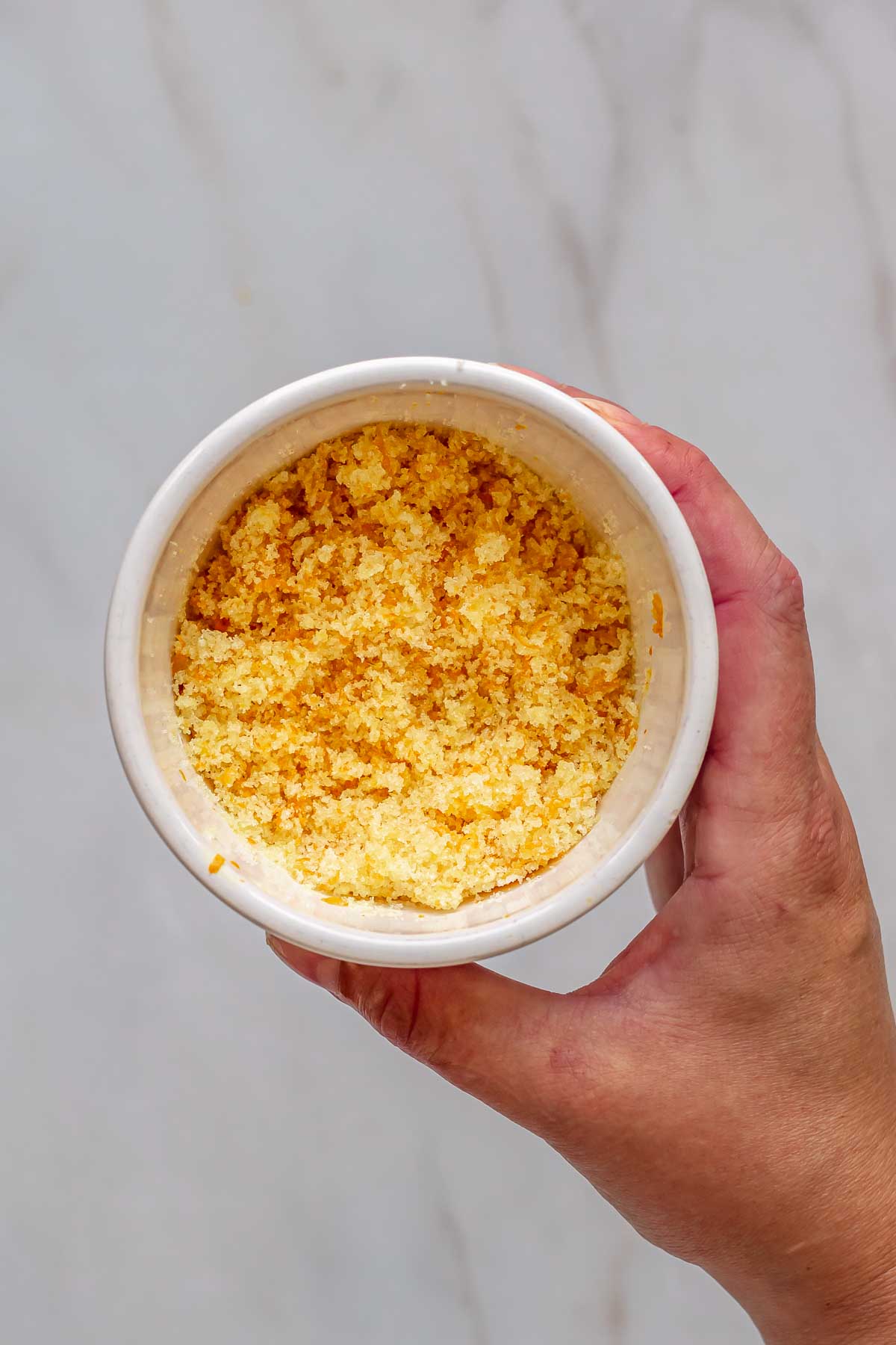 Orange zest and sugar mixed in a bowl.