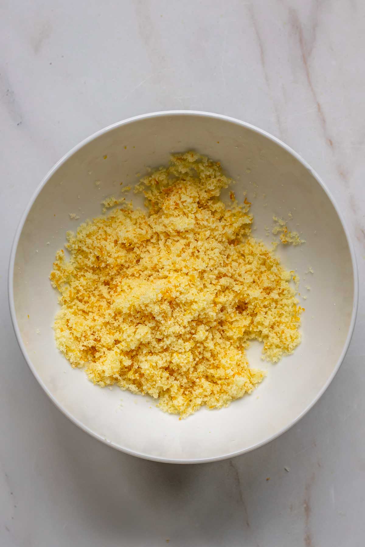 Orange zest and sugar mixed together in a bowl.