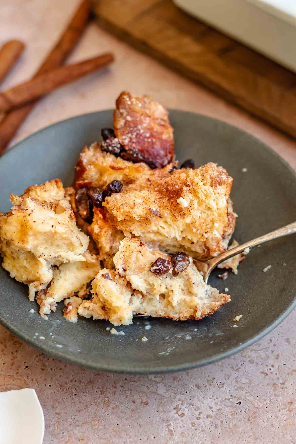 Cinnamon bread pudding in a bowl with a spoon.