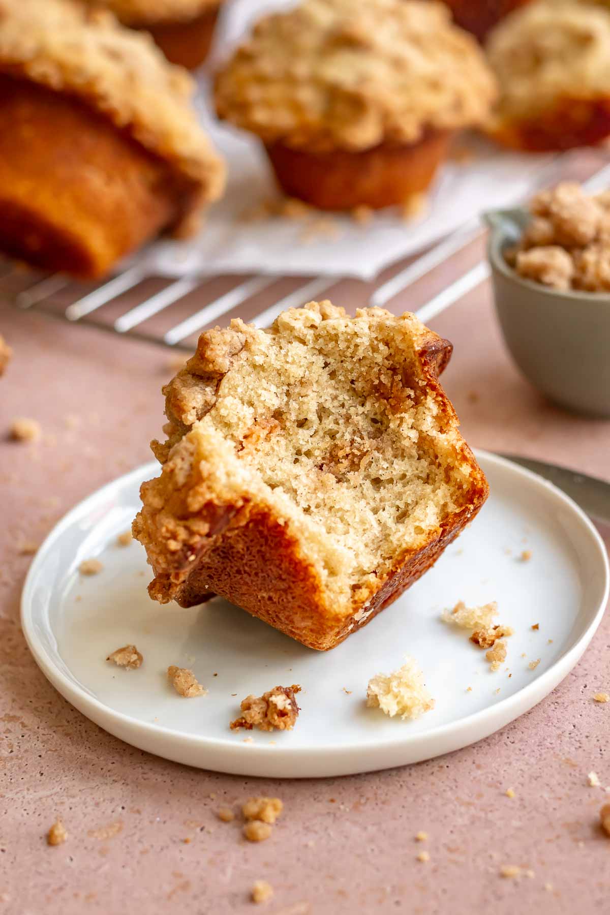 Cinnamon streusel muffin on a plate with a bite removed.