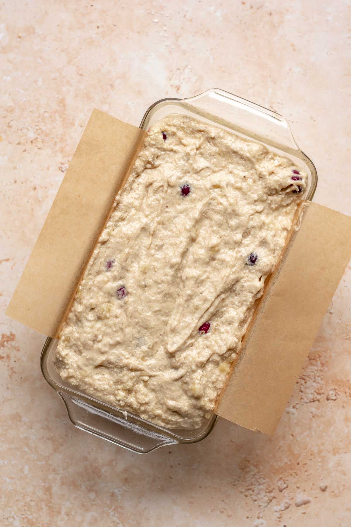 Banana cranberry bread in a loaf pan before baking.