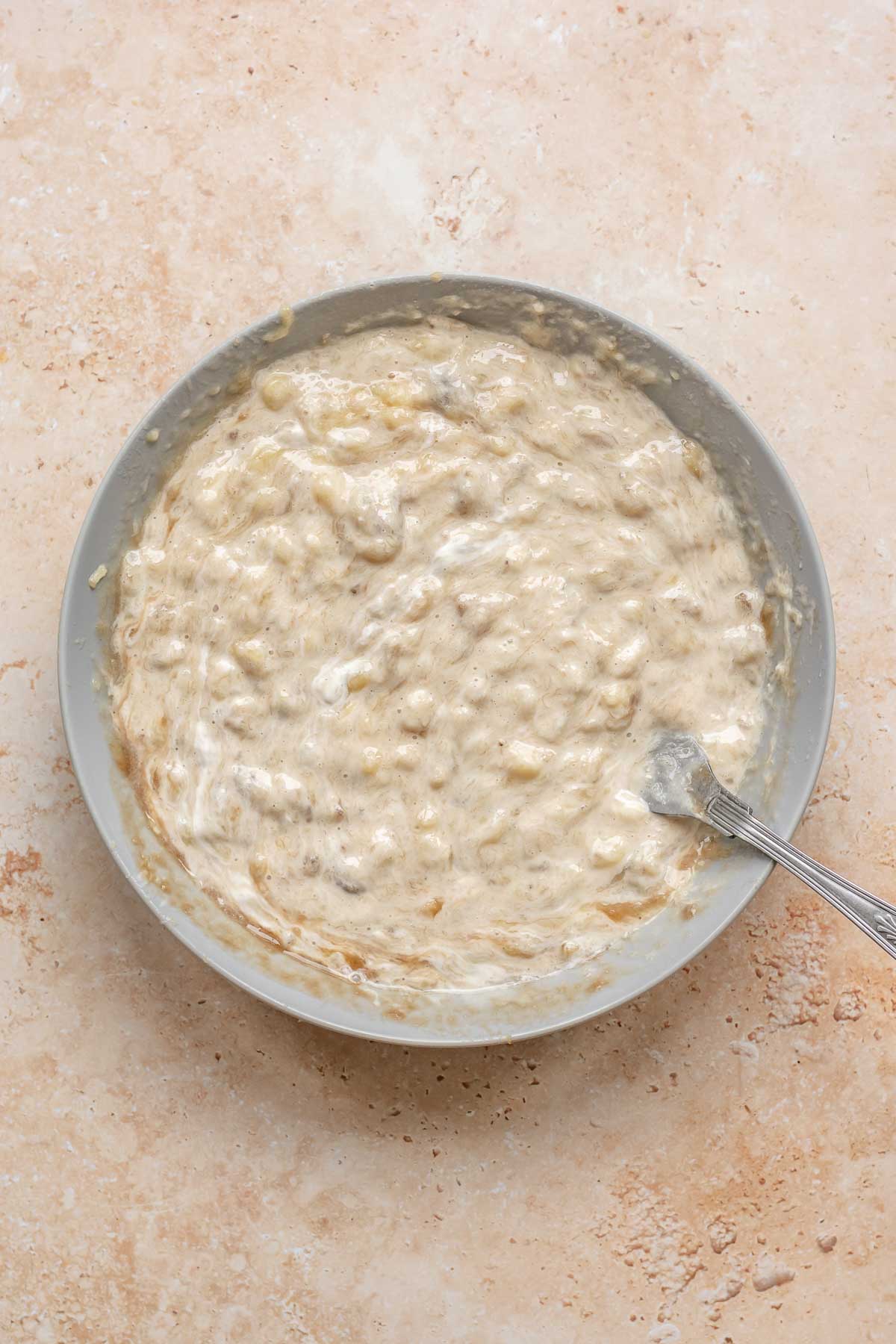 Banans and sour cream mixed in a bowl.