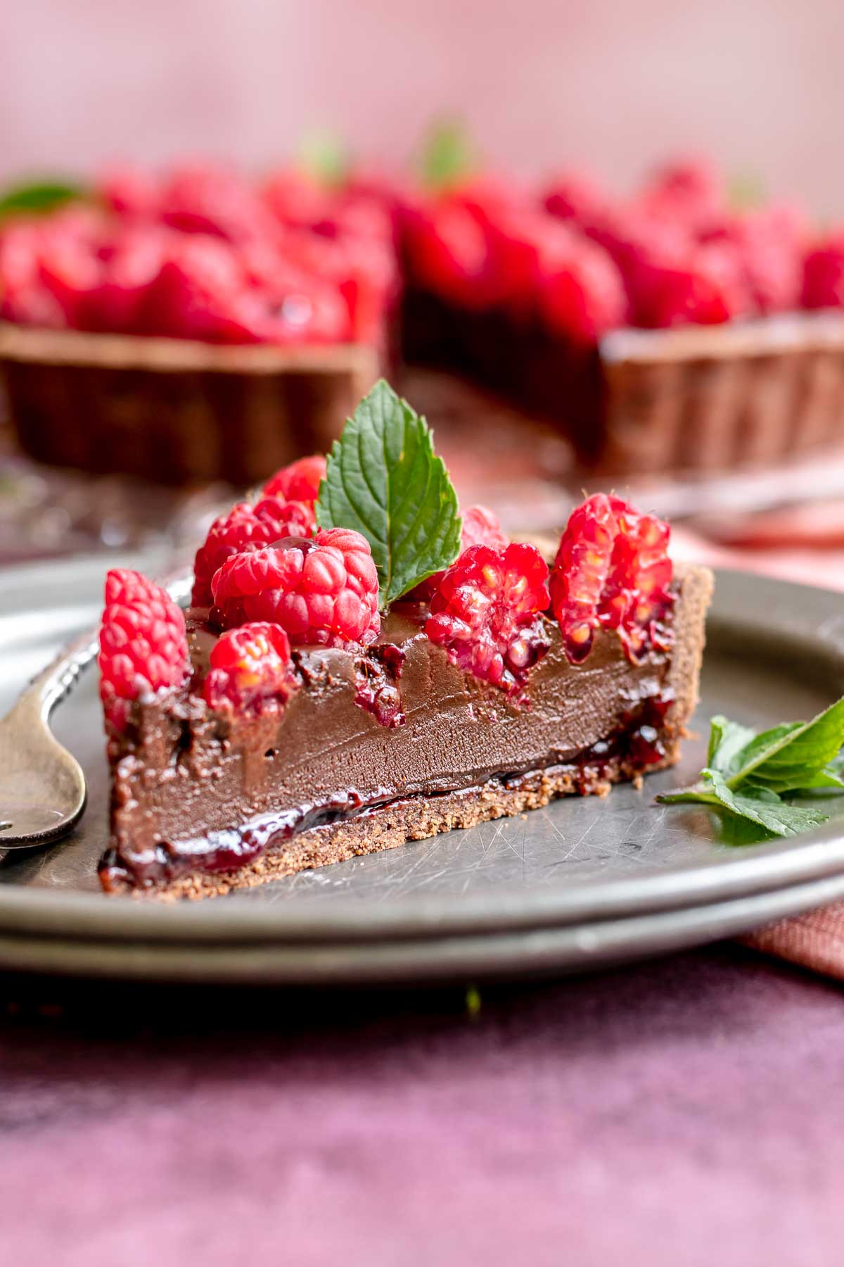 A slice of chocolate rapsberry tart on plater.