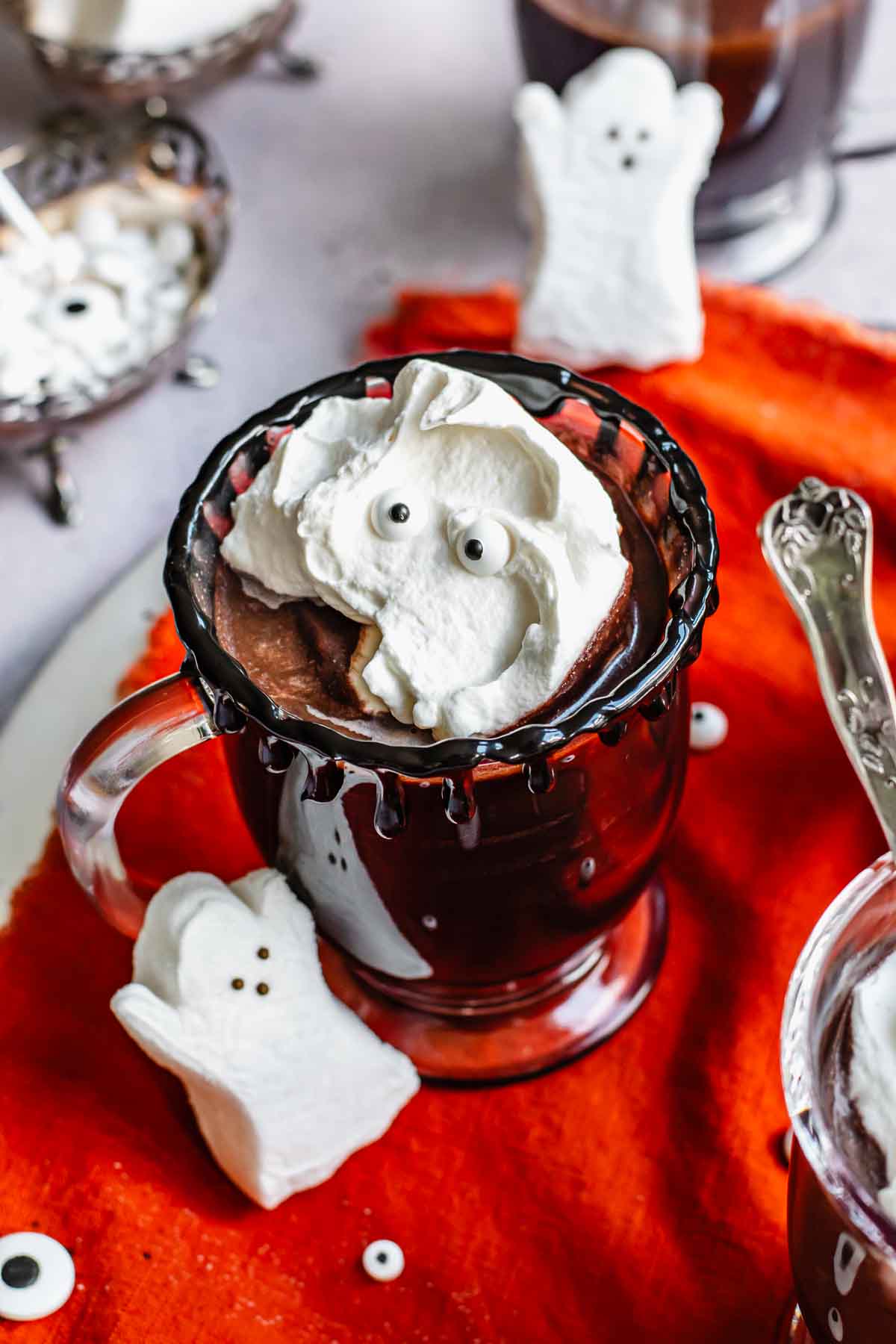 Halloween hot chocolate in a clear glass with toppings.