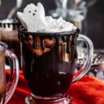 Halloween hot chocolate in a clear glass with a peep ghost on top.