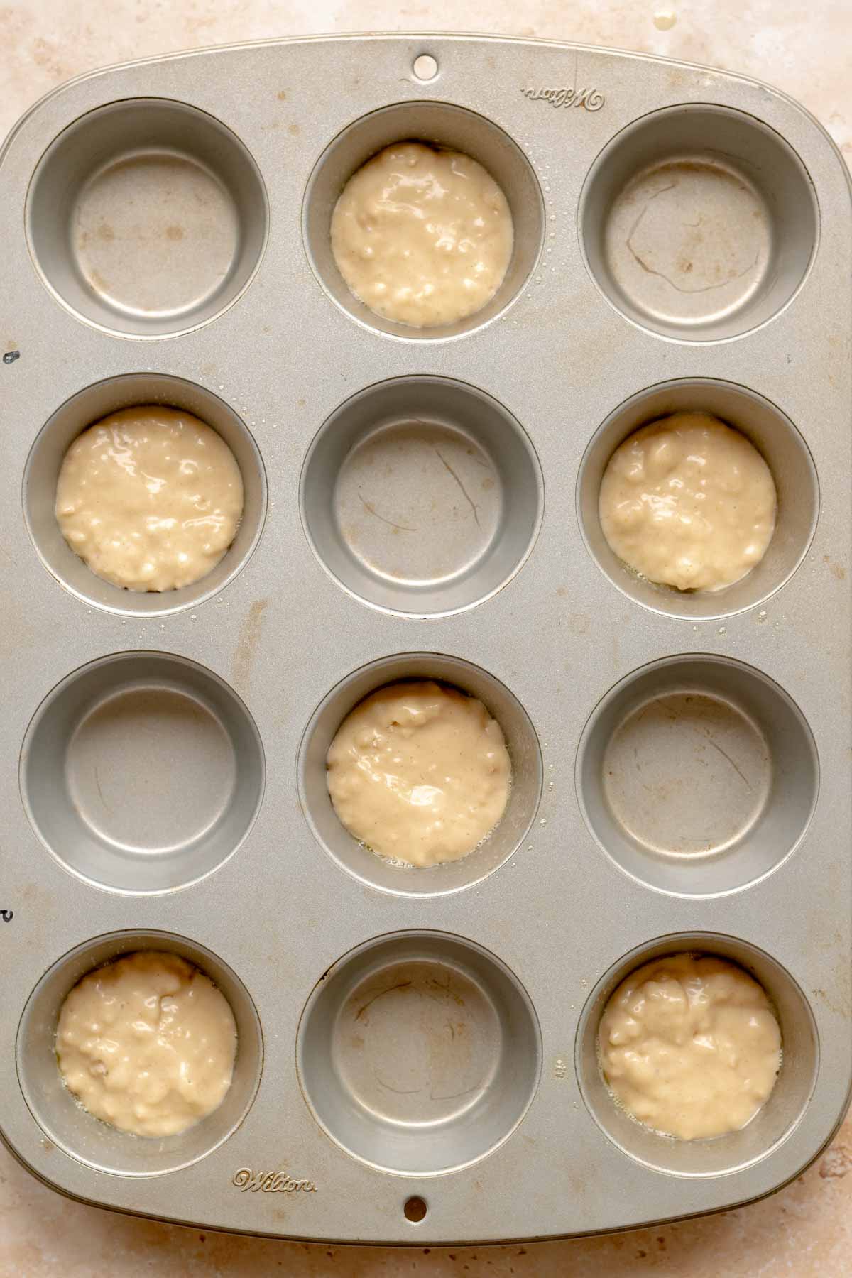 A small amount of batter in a muffin tin.