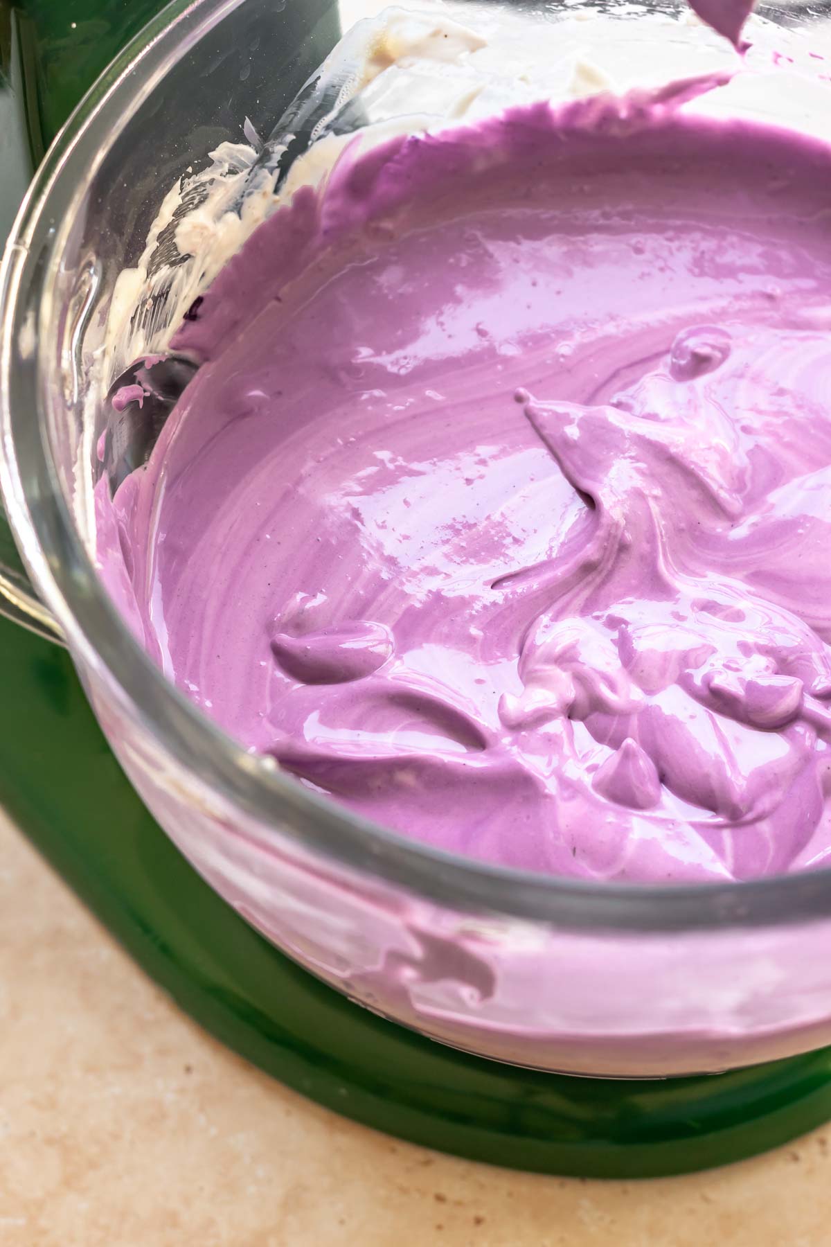 Purple use cheesecake batter in a stand mixer bowl.