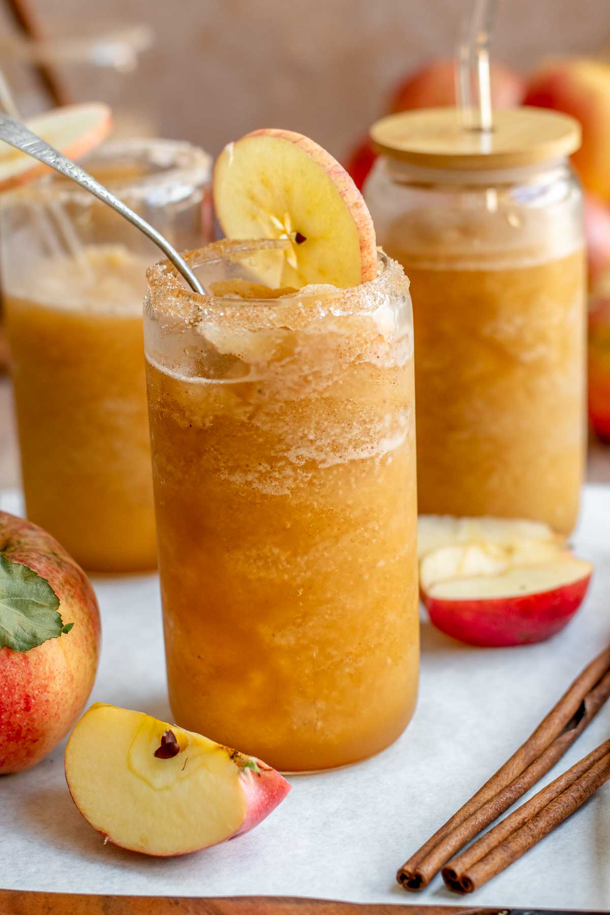 Apple cider slushie in glasses with straws.