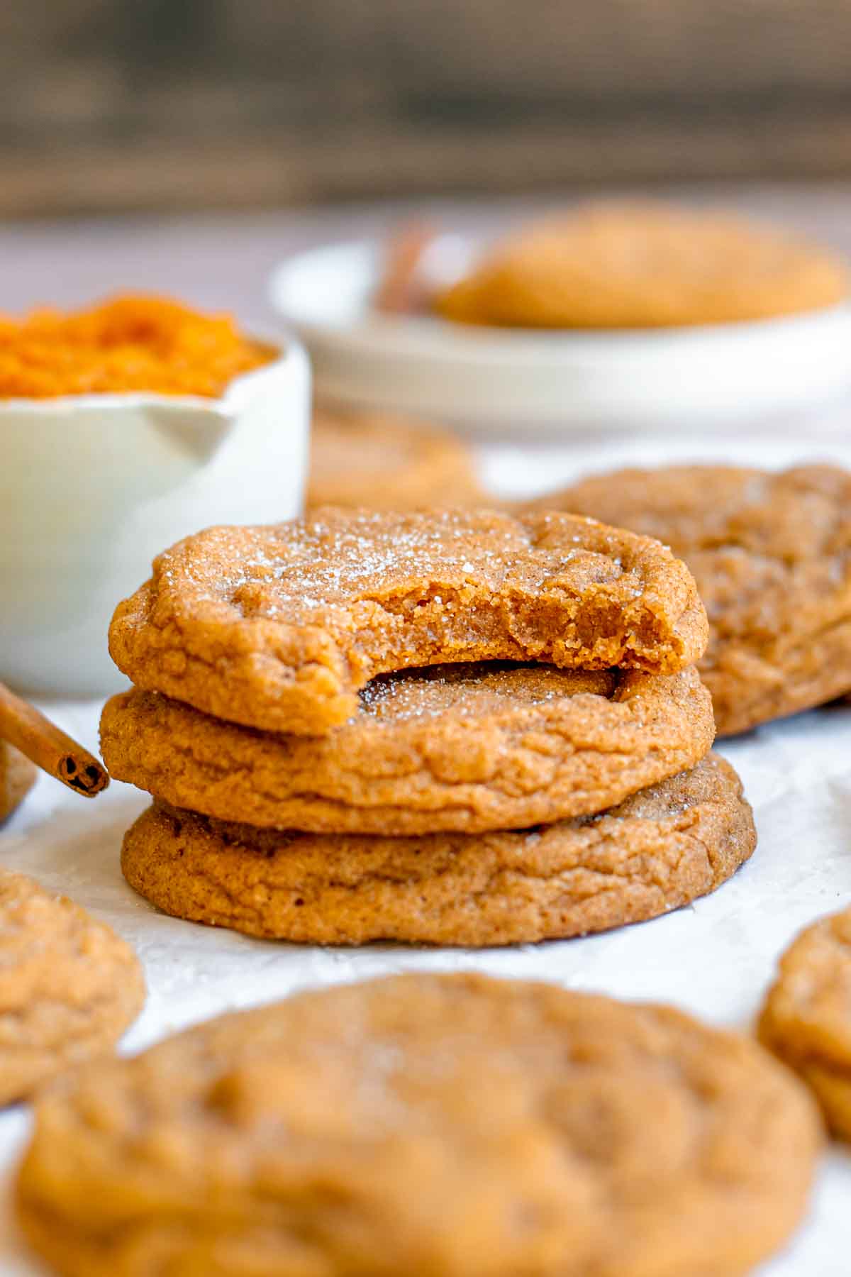 A stack of chewy pumpkin cookies. The top one has a bite removed.
