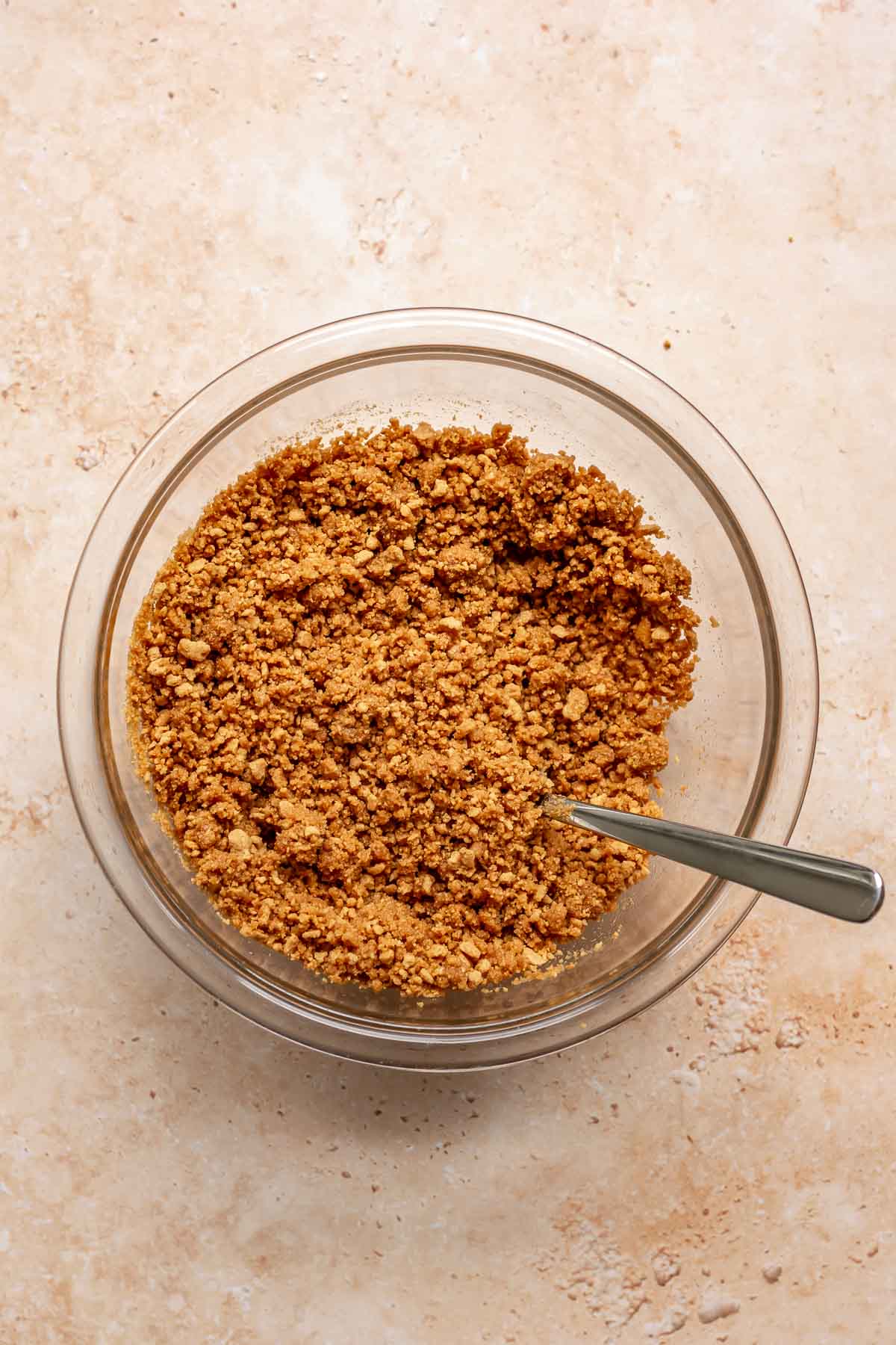 Ginger snap crumbs in a bowl with a fork.