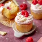 Raspberry white chocolate cupcake on a small plate.