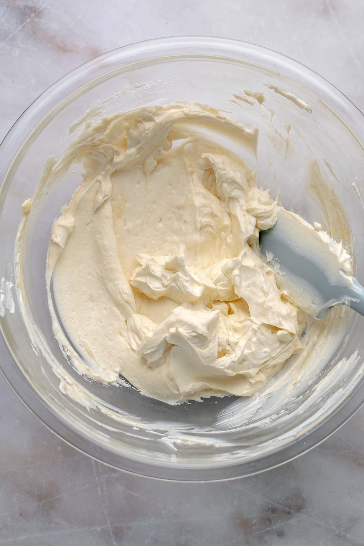 Cream cheese smoothed out in a mixing bowl.