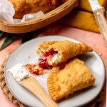 Guava and cheese empanada broken open on a plate.