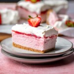 Sliced strawberry cheesecake bar on a plate.