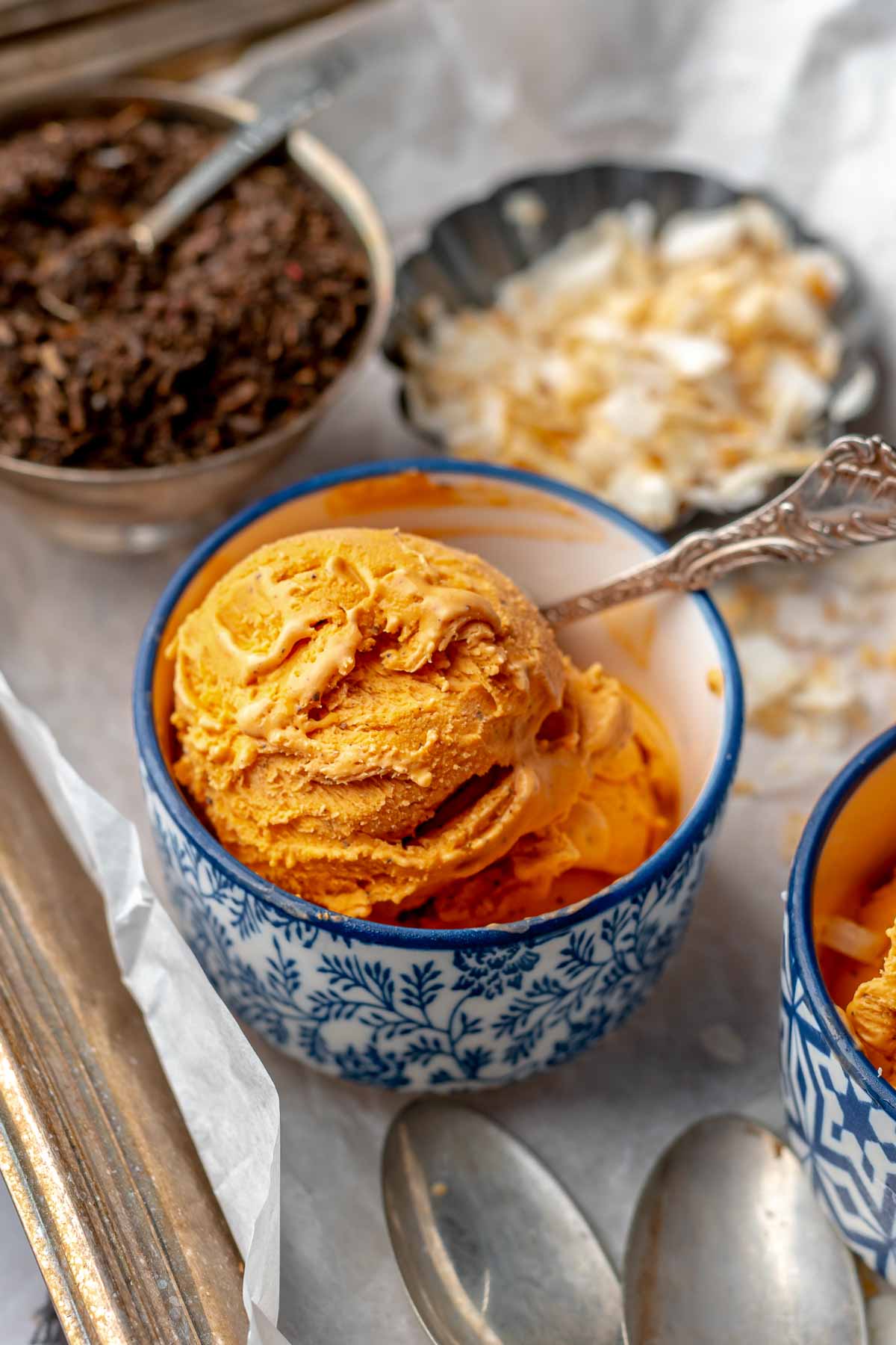 Thai tea ice cream in a bowl with a spoon.