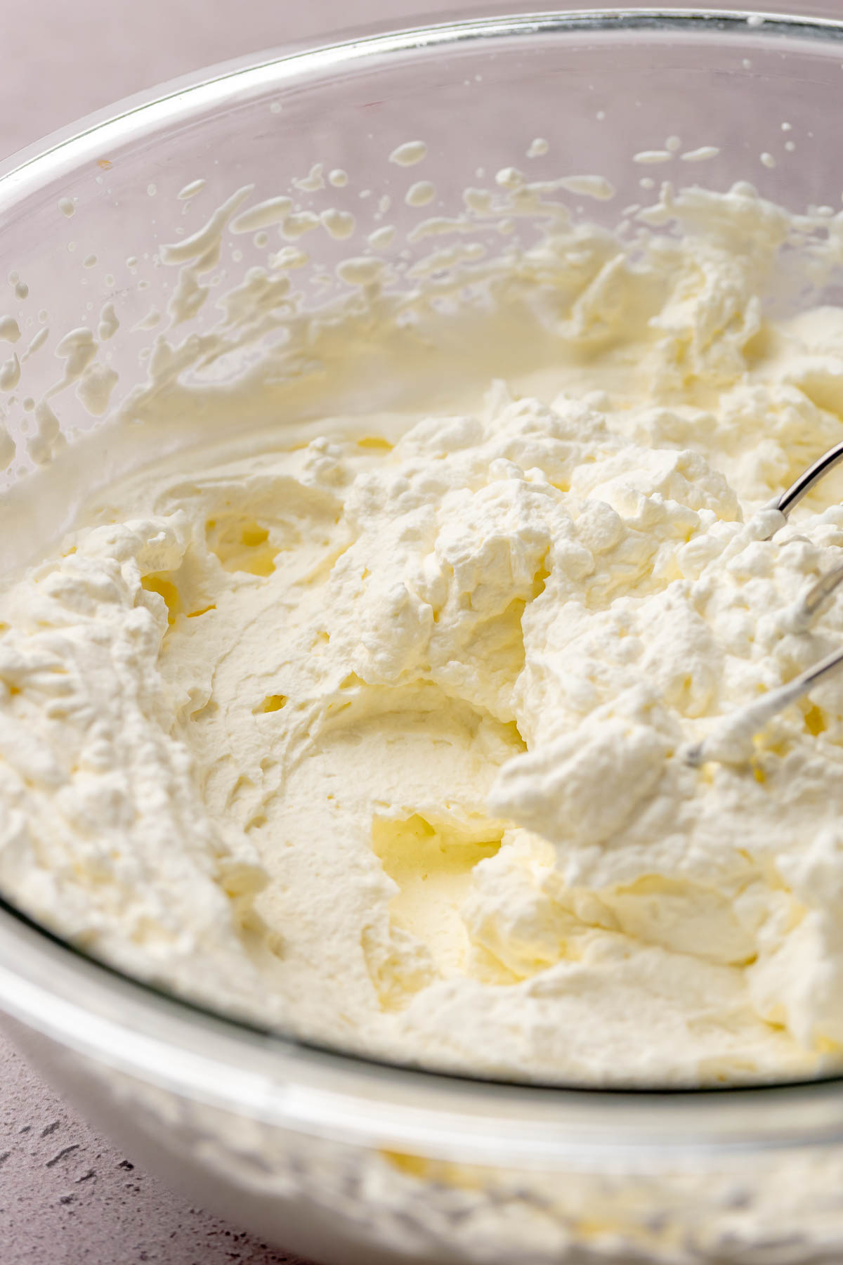 Beaters and whipped cream in a bowl.