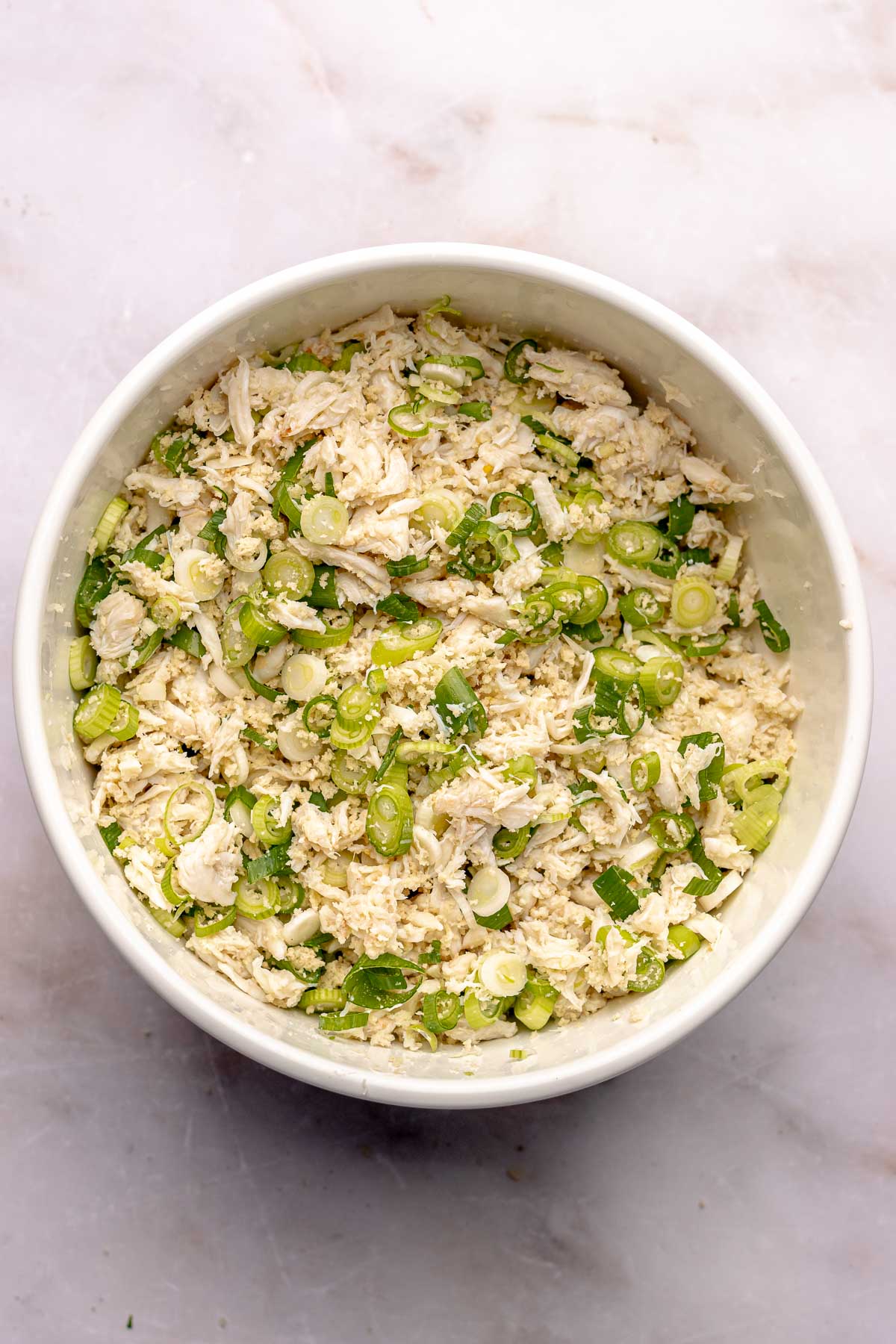 Crab, scallions, and bread crumbs in a bowl.