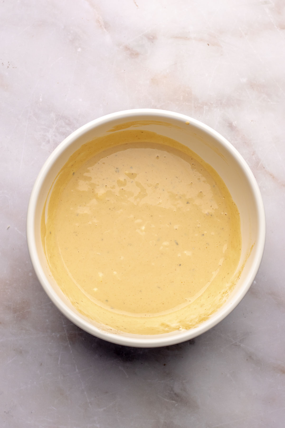 Wet ingredients for crab cakes in a bowl.