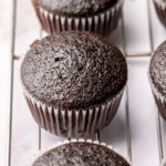 Chocolate cupcakes on a wire rack.