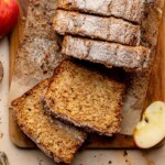 Apple cider cake sliced on a cutting board.
