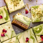 Sliced baklava cheesecake bars on parchment paper.