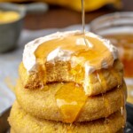Honey being drizzled onto a stack of cornbread cookies.