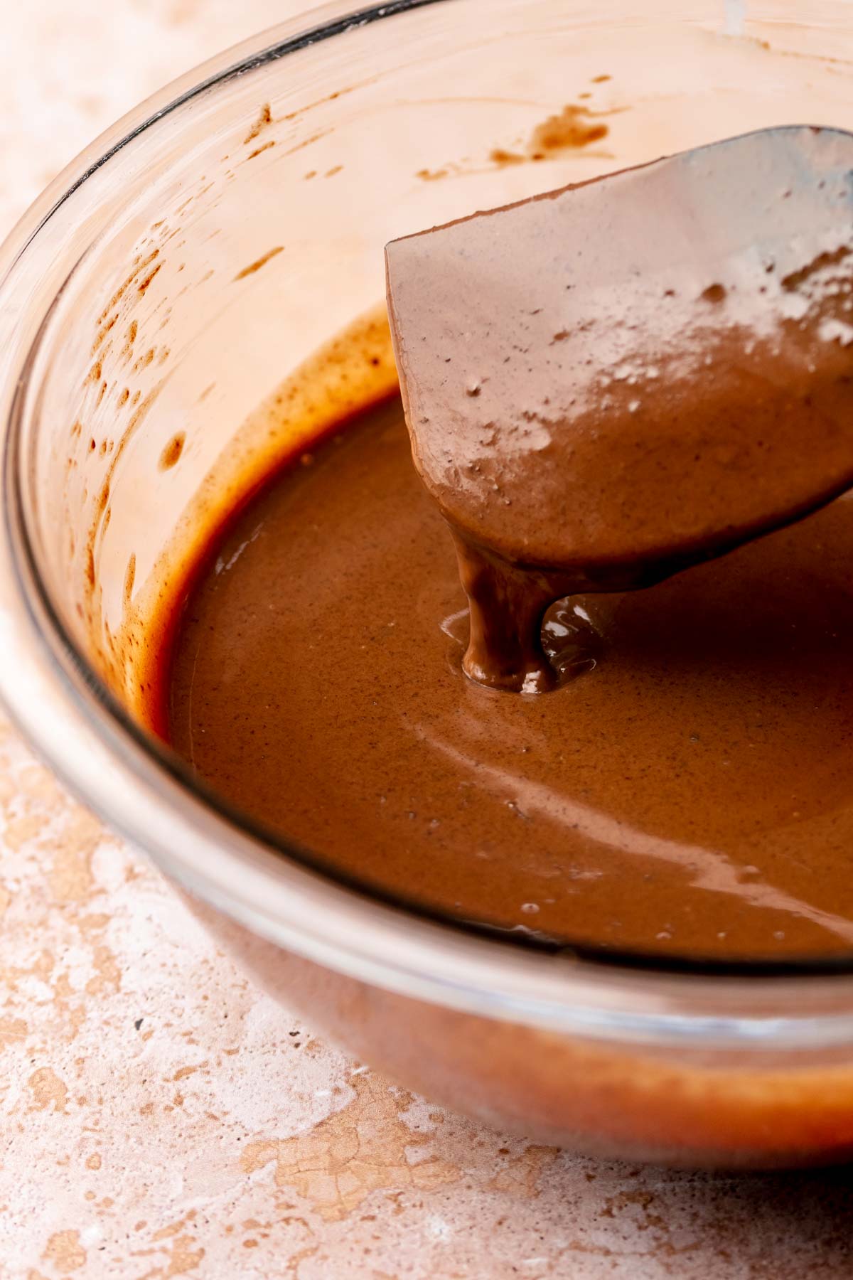 A spatula mixes chocolate ganache.