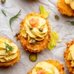 Garnished fried deviled eggs on a platter.