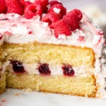 Sliced raspberry coconut cake on a cake stand.