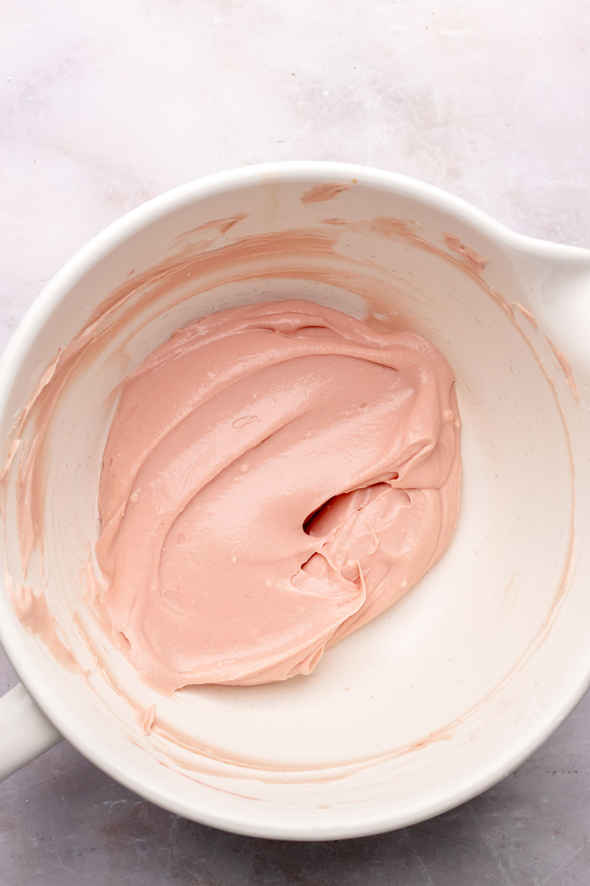 Raspberry cream cheese frosting base in a bowl.