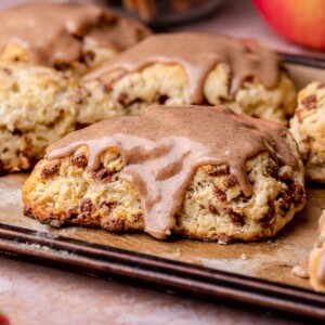 An iced cinnamon apple scone on a sheet pan.