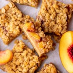 A slice of peach crumble bars sliced laying on its side.