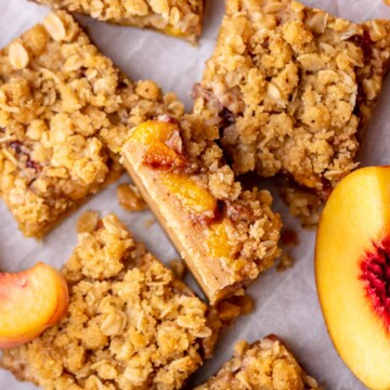 A slice of peach crumble bars sliced laying on its side.