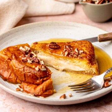 Pumpkin stuffed french toast sliced open on a plate.