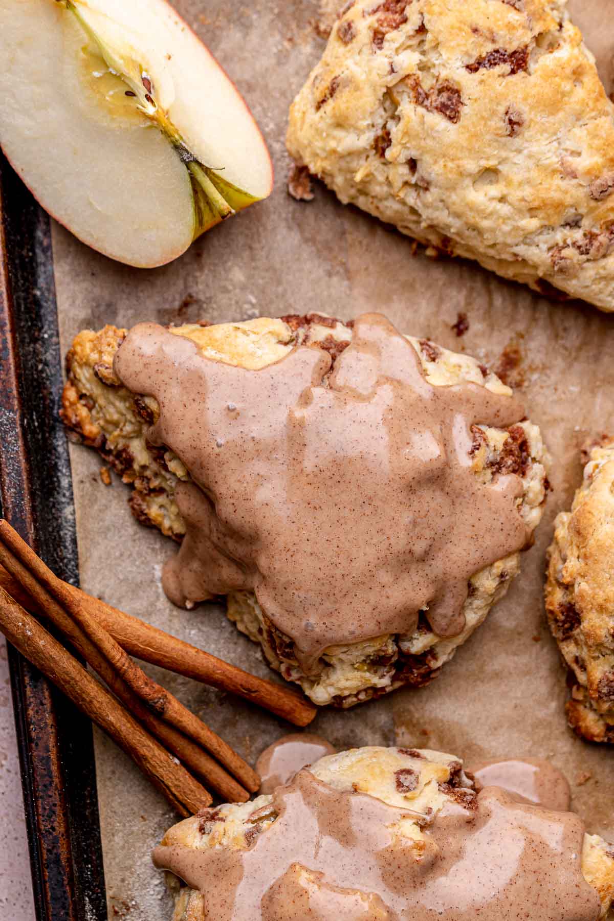 An iced cinnamon apple scone on a sheet pan.
