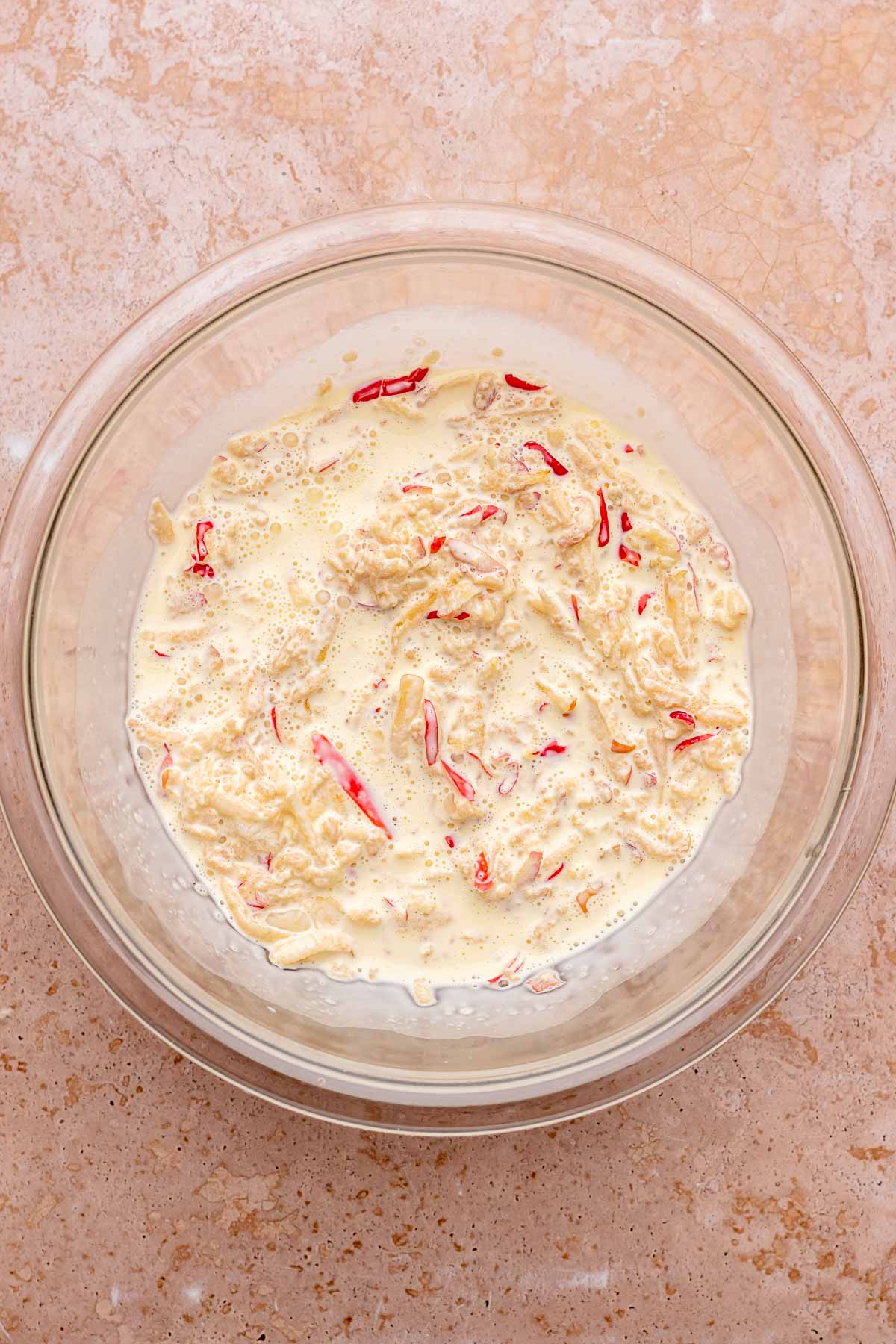 A bowl of liquid ingredients mixed with apples.