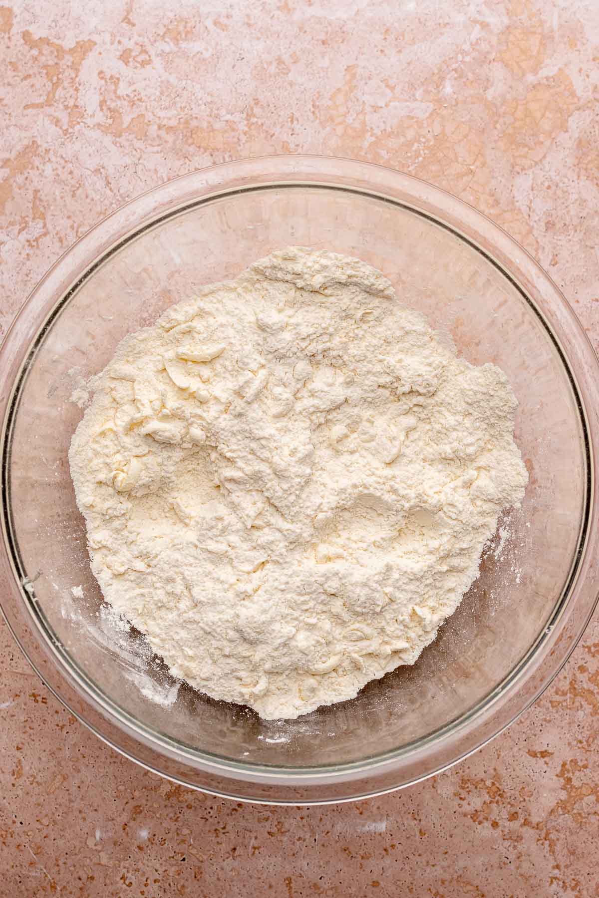 Shredded butter and flour mixed in a bowl.