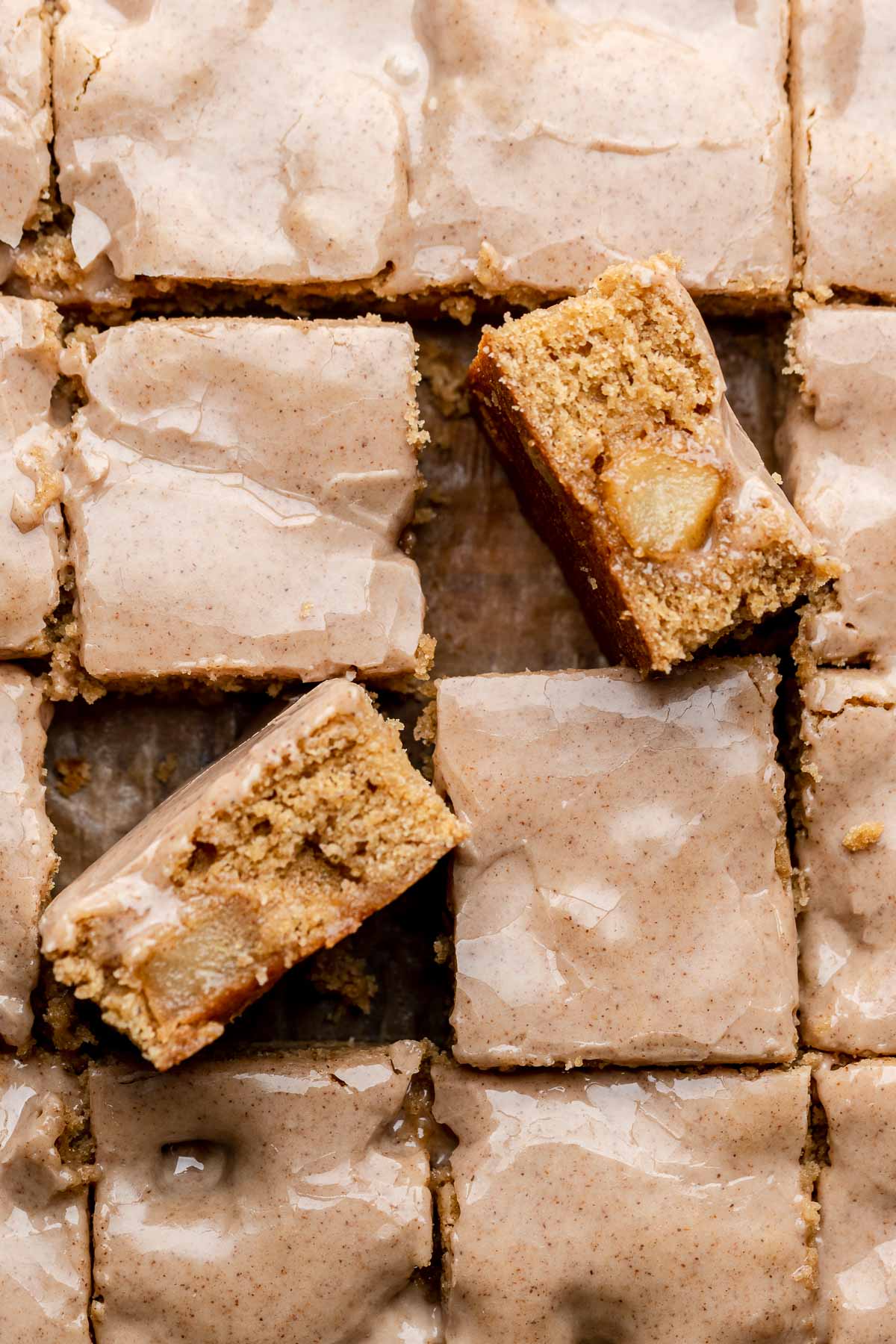 Cinnamon apple blondies cut into pieces. Two are laying on their edges.