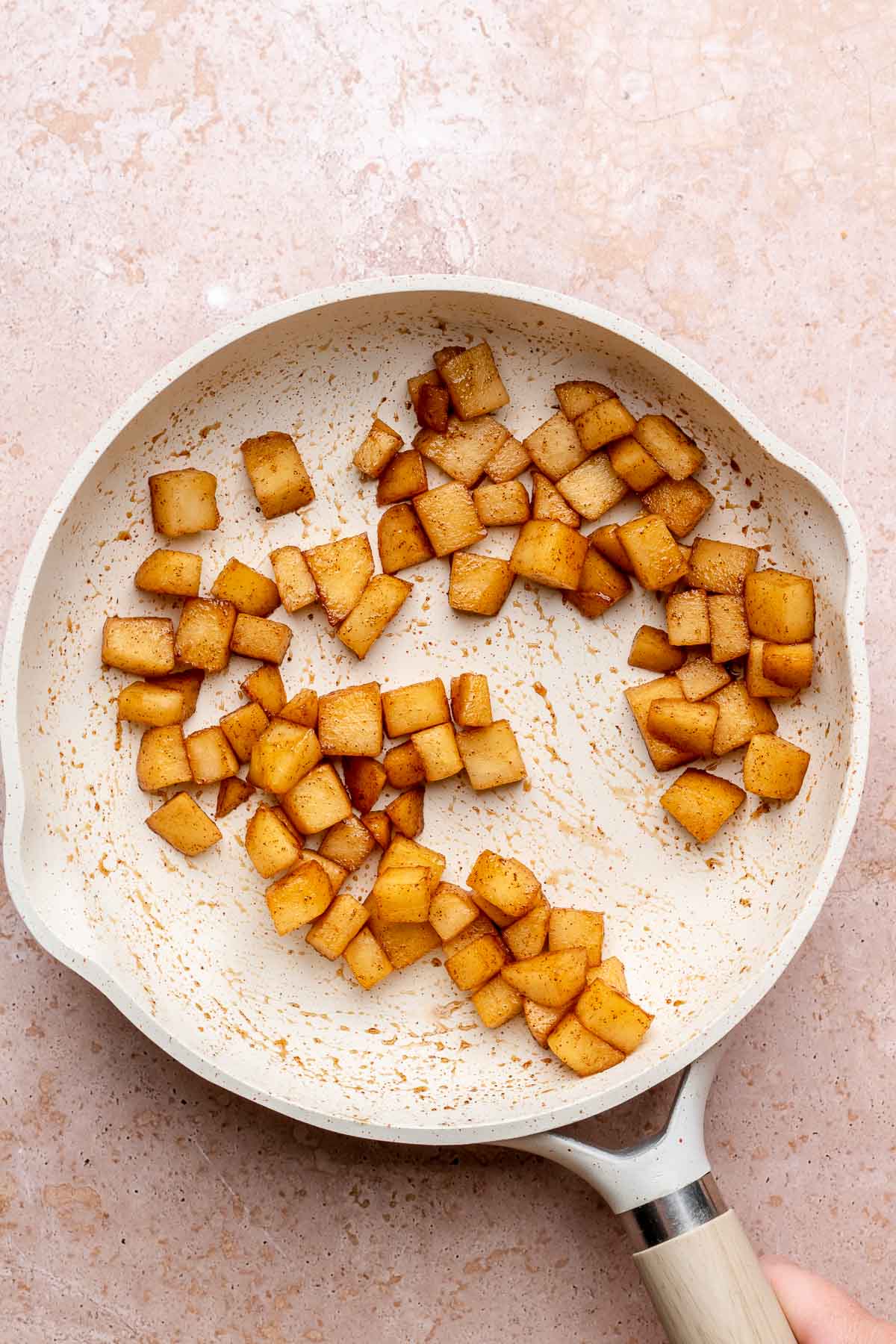 Cut cinnamon sugar apples in a pan.