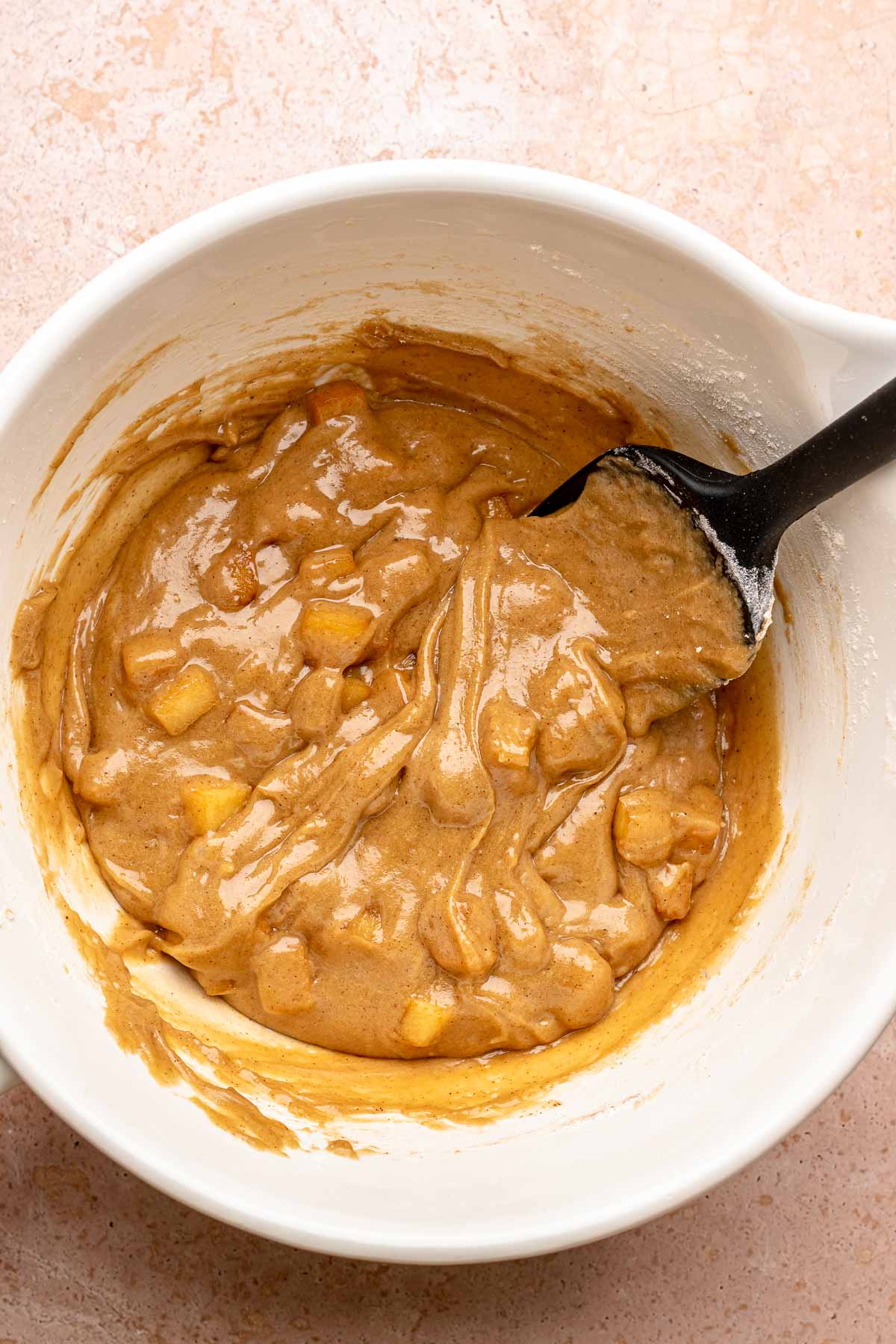 A spatula mixes blondie batter with apples.