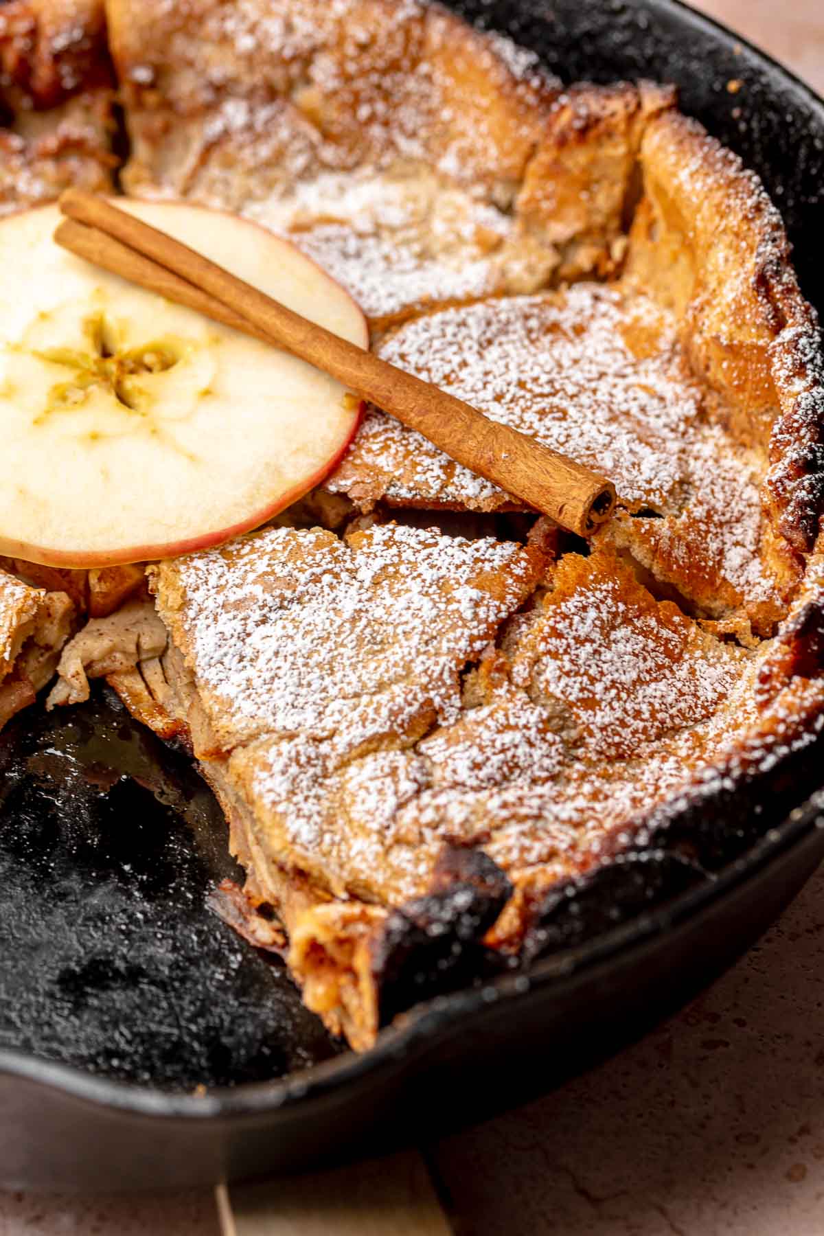 Sliced appled dutch baby in a pan.