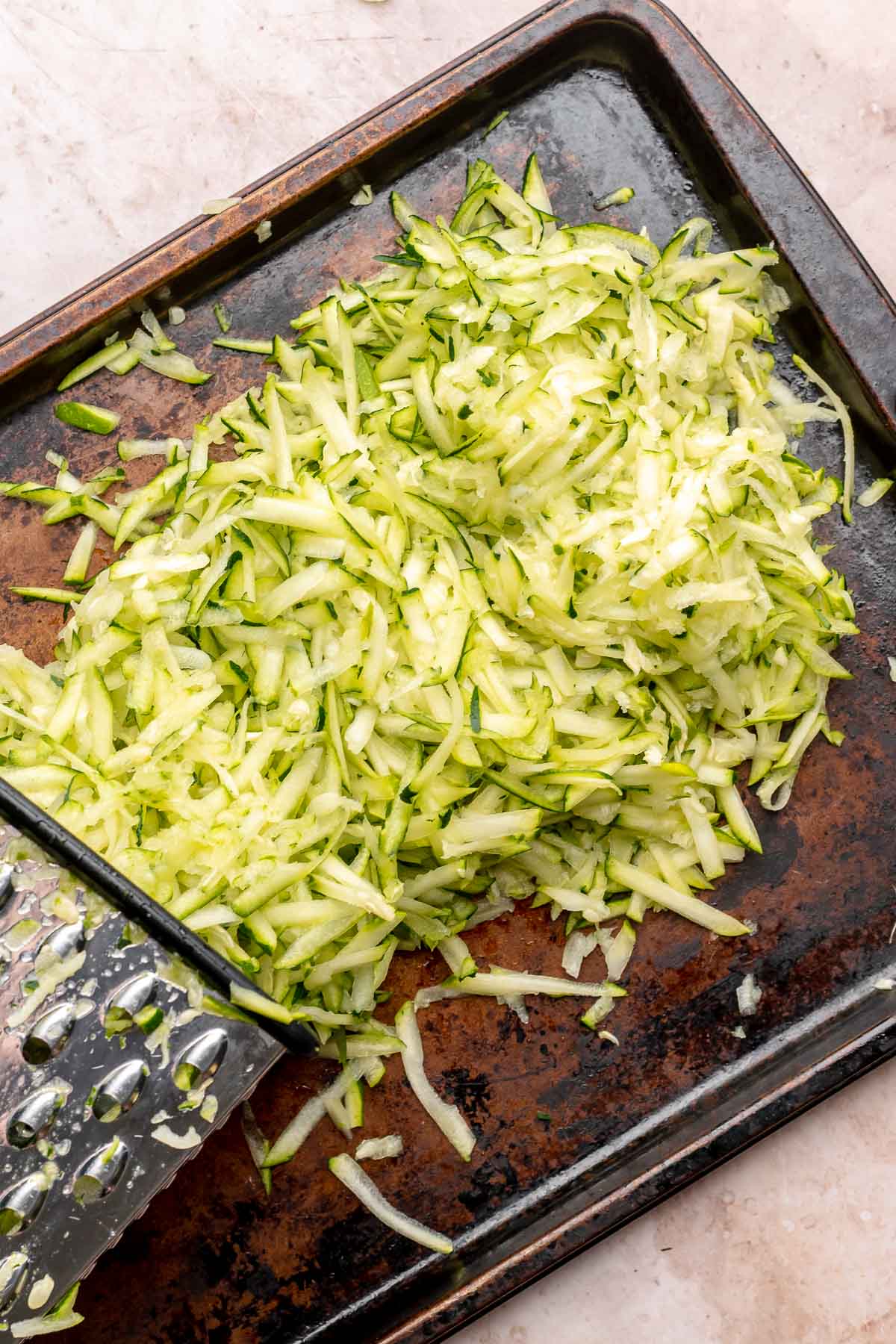 Grated zucchini on a cookie sheet.