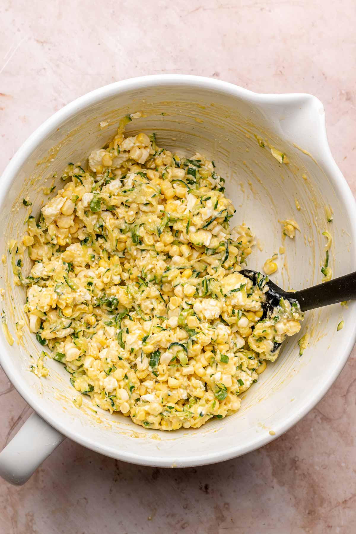 Corn and zucchini fritter batter in a bowl.