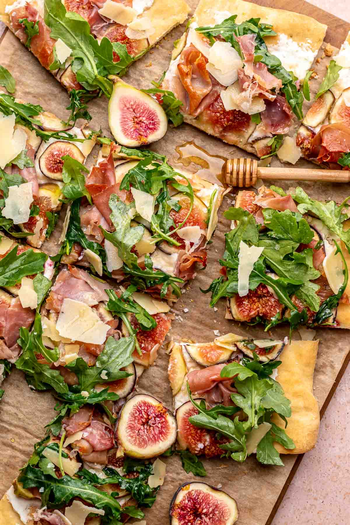Sliced fig and prosciutto flatbread on a cutting board.