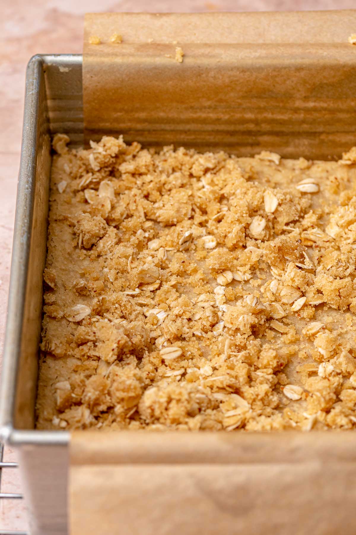 Pieces of oatmeal crumble on baked shortbread.