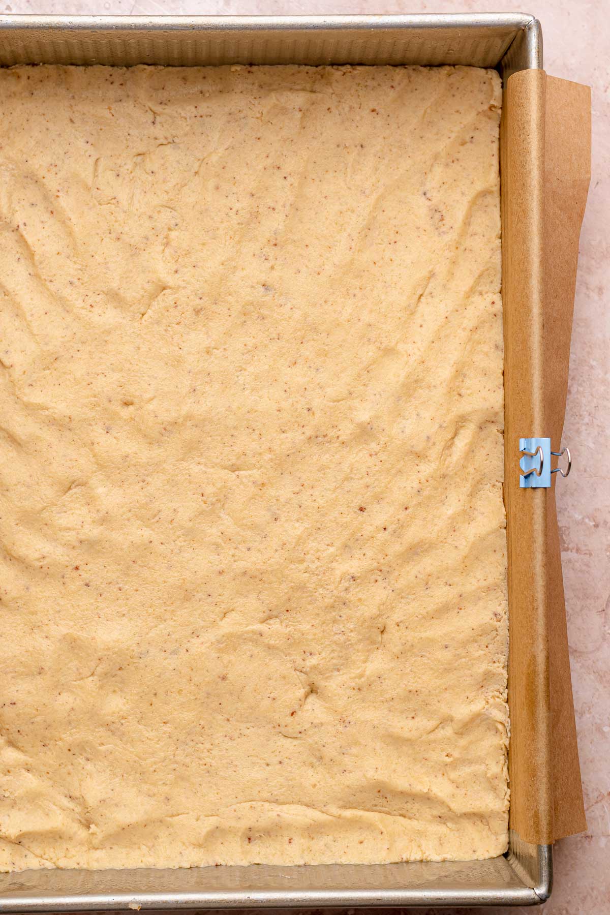 A layer of pre-baked shortbread dough pressed into a pan.