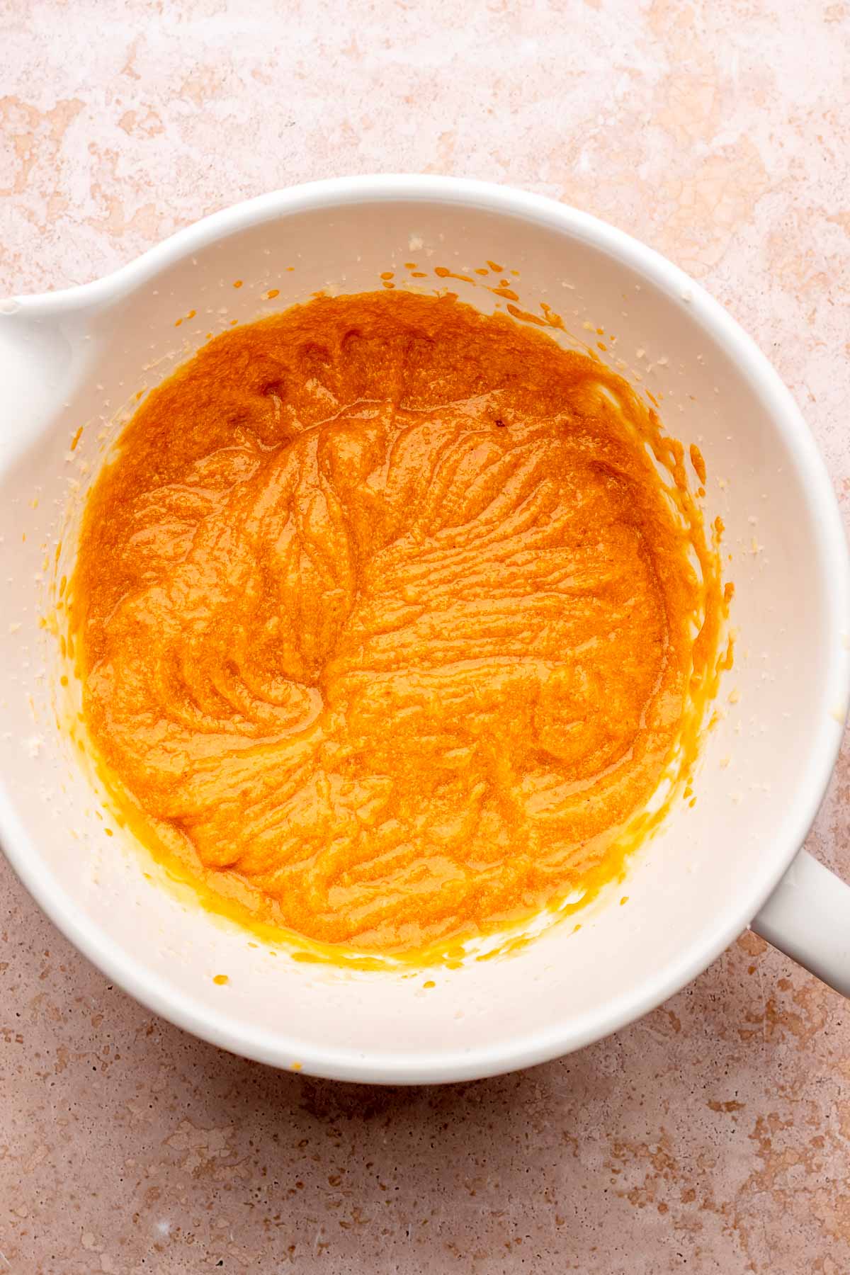 Creamed pumpkin cake batter in a bowl.